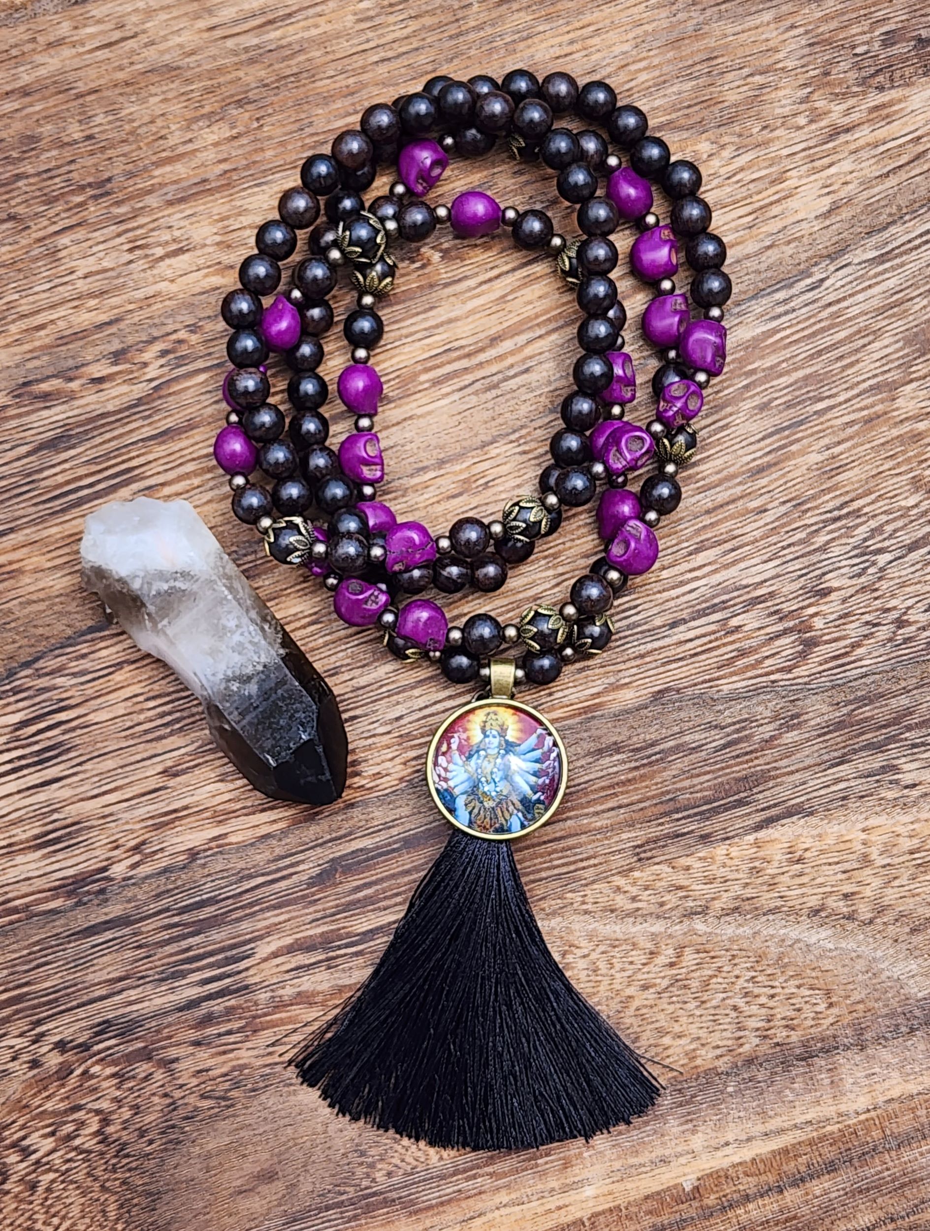 Kali Ma Mala featuring ebony wood, purple skulls, and black tassel